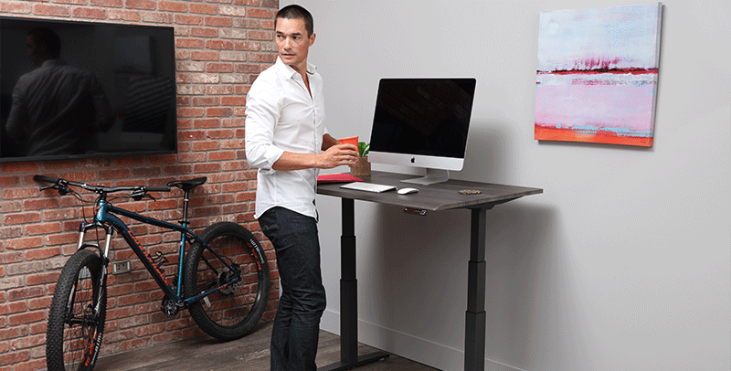 Man Standing at SmartMoves Adjustable Height Desk