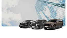 Drei Hyundai Elektrofahrzeuge – IONIQ 6, TUCSON Plug-in-Hybrid und SEVEN Concept – stehen nebeneinander vor einem Hochhaus mit Glasfassade und Himmelspiegelung.