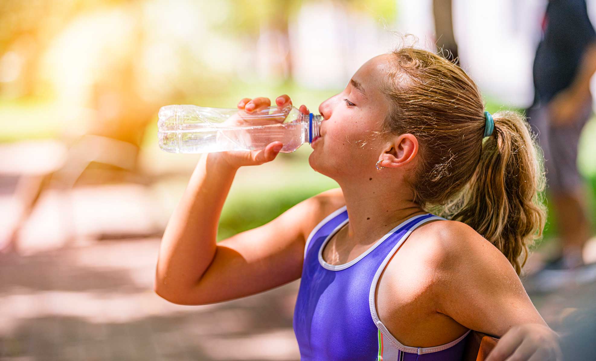 girl drinking water after working out