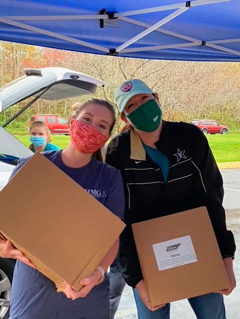 volunteers carrying boxes of food