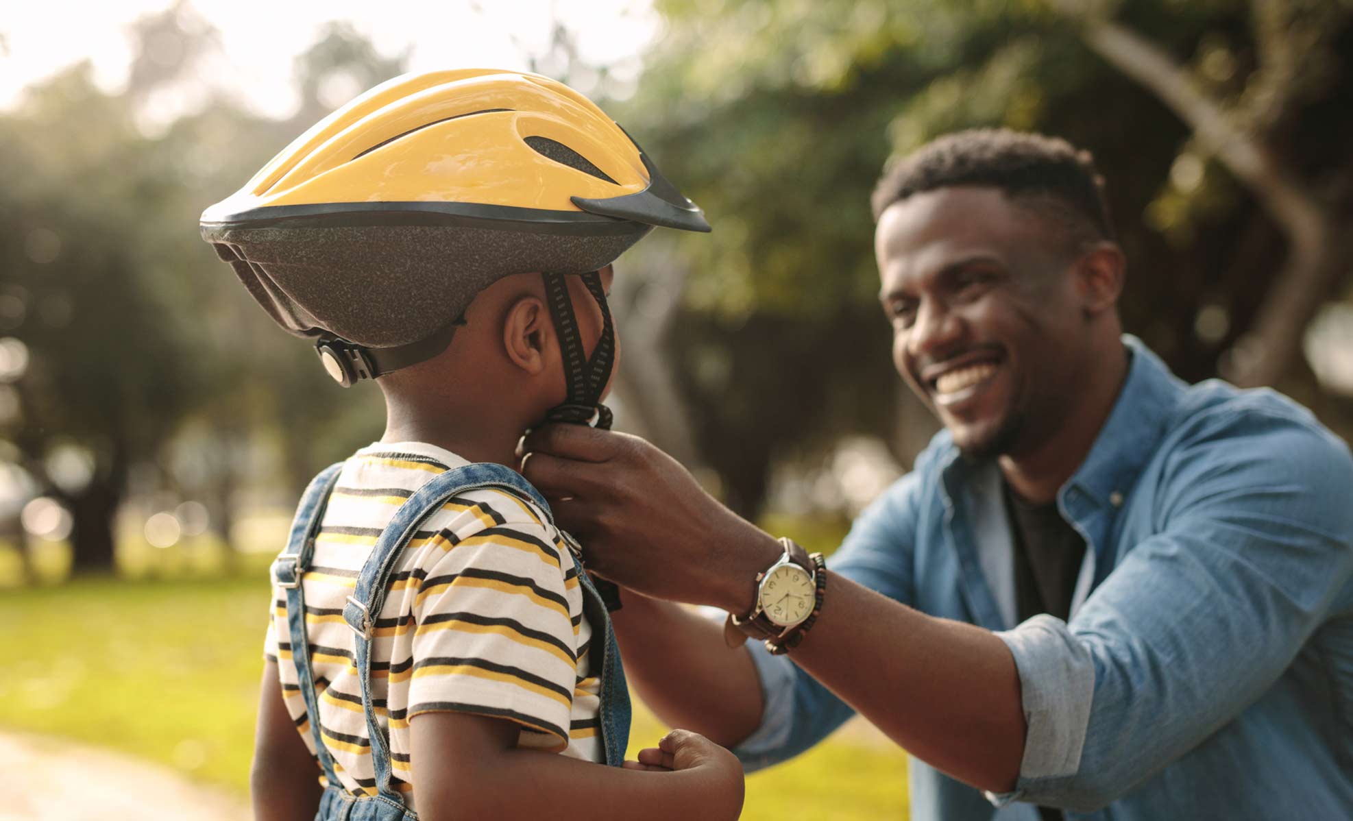 dad helping son with bike helmet