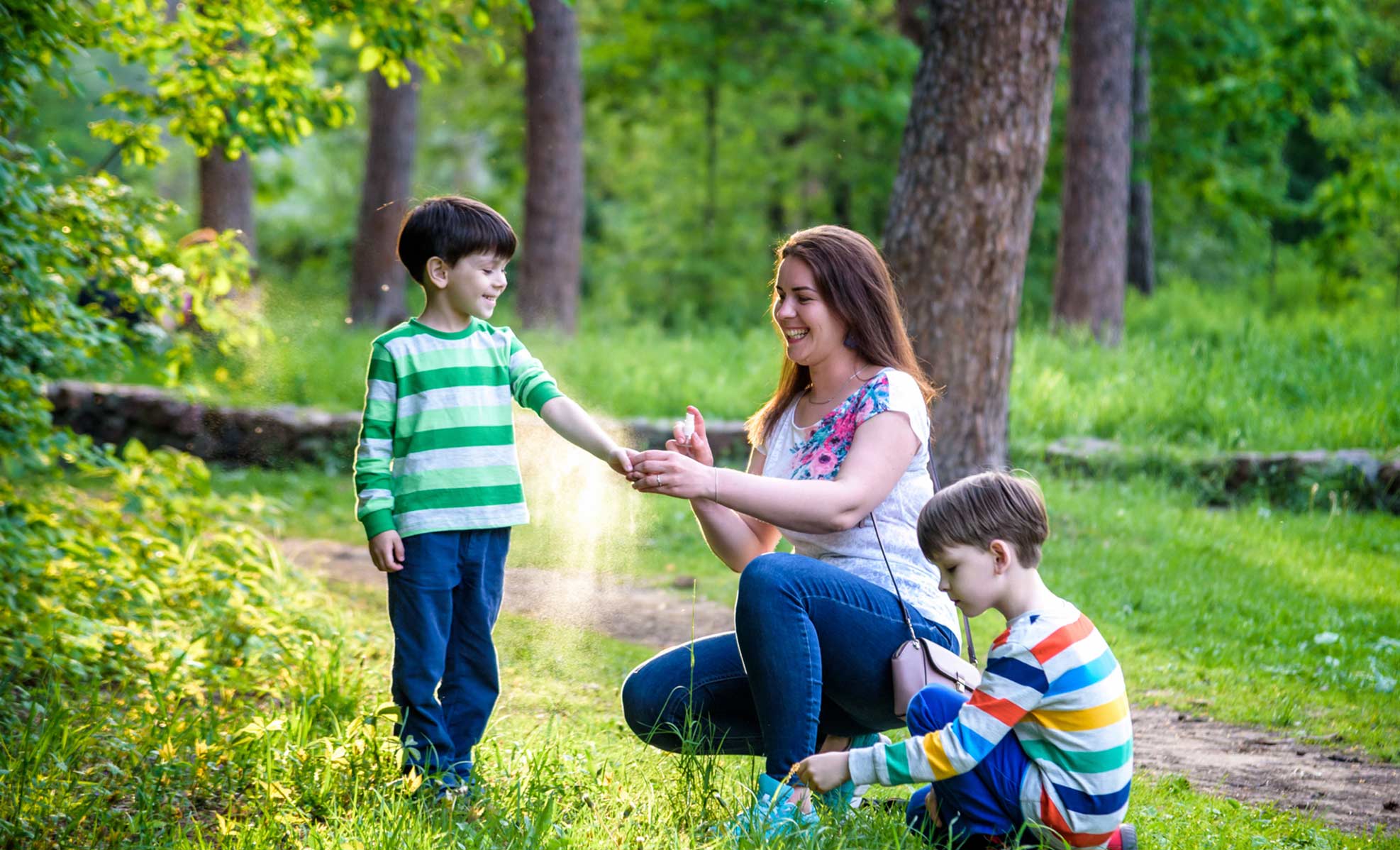 mother putting bug spray on child