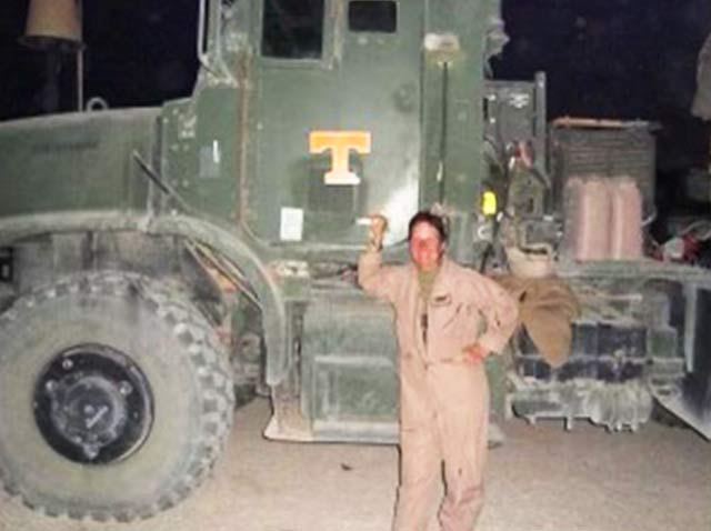 Dee in front of big truck while working in the Navy