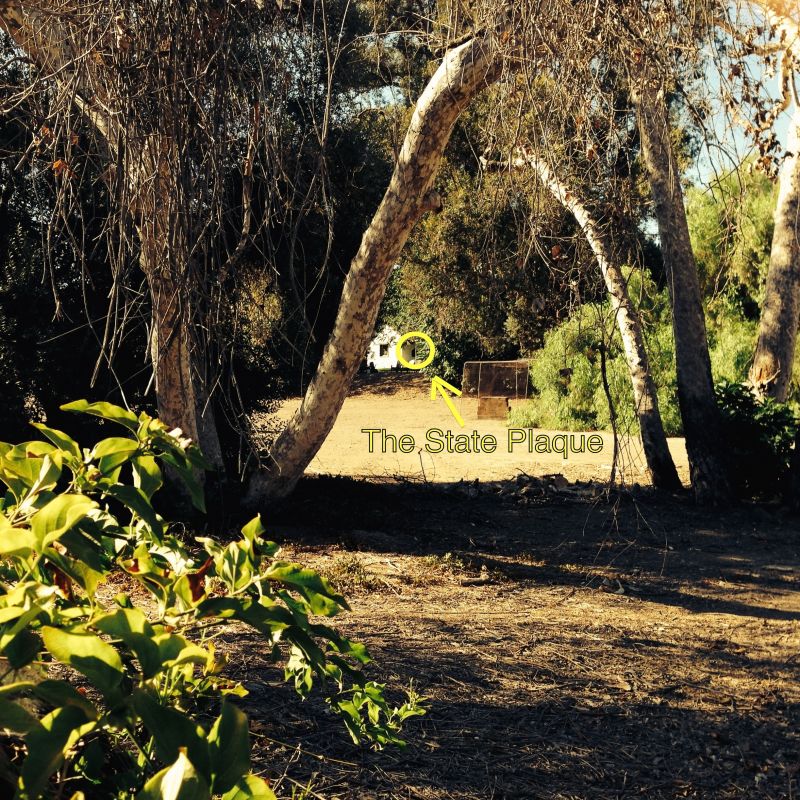 Looking over the fence through bushes, we could barely spot the sign.