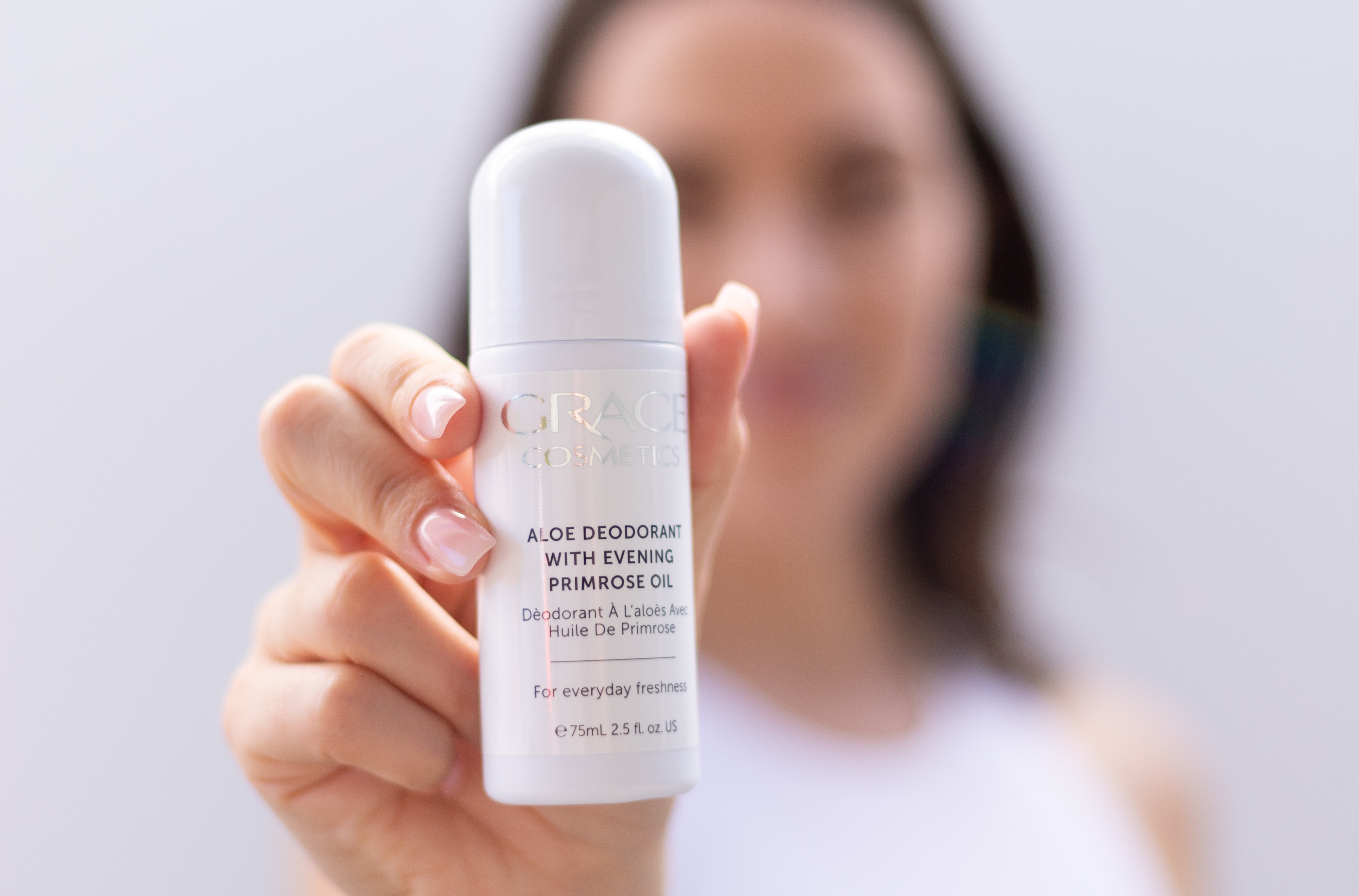 Woman holding Aloe Deodorant to camera