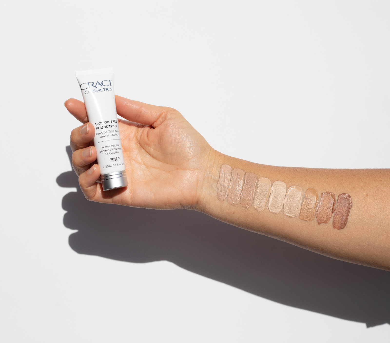 Hand holding Aloe Oil Free Foundation product with shade selection on forearm