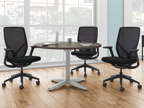 A Preside round conference table with three Flexion task chairs.