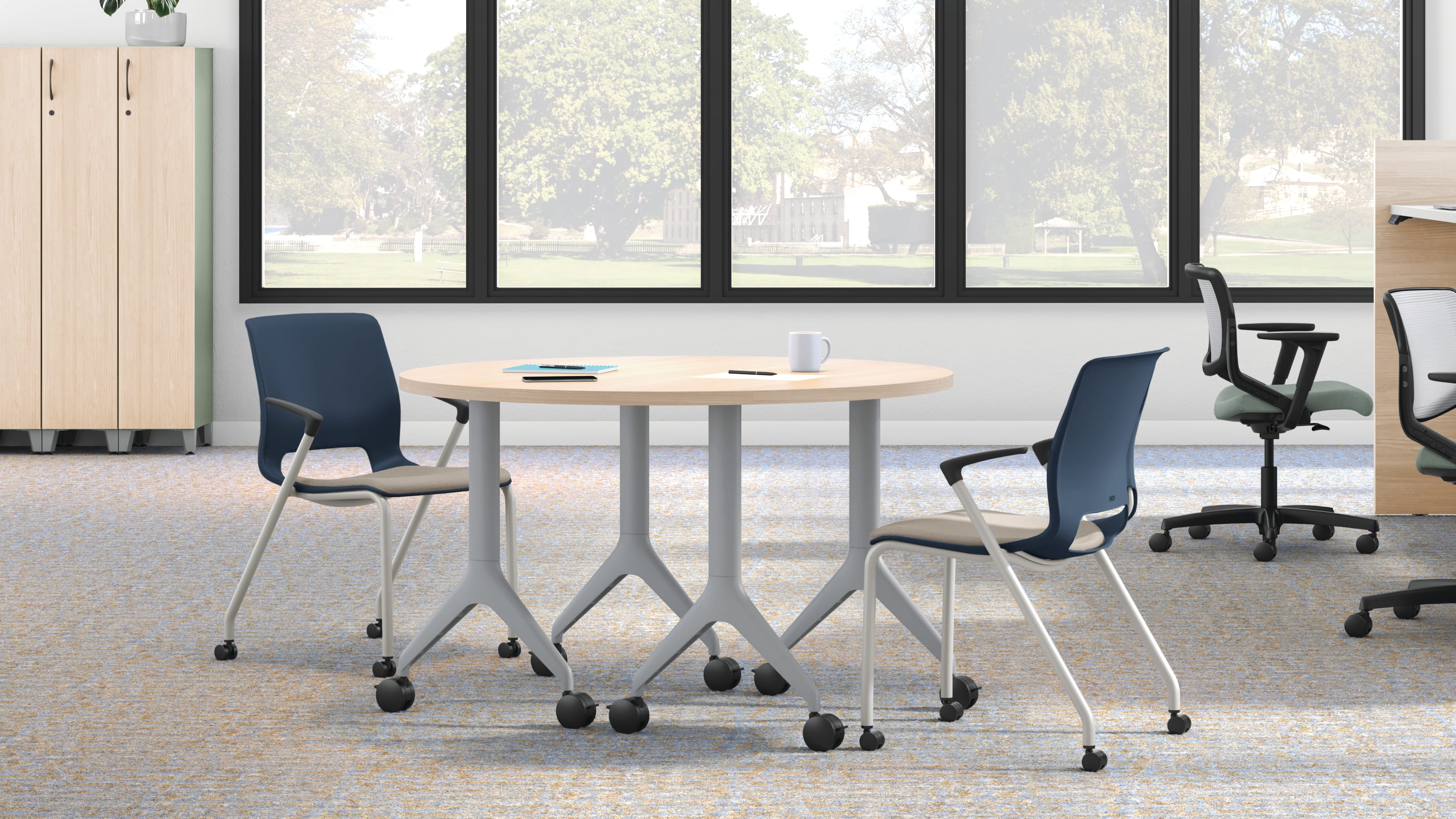 Open workstation view of Motivate 4-leg stacking and flex-back chair with Contain wardrobe locker and Motivate half-round table