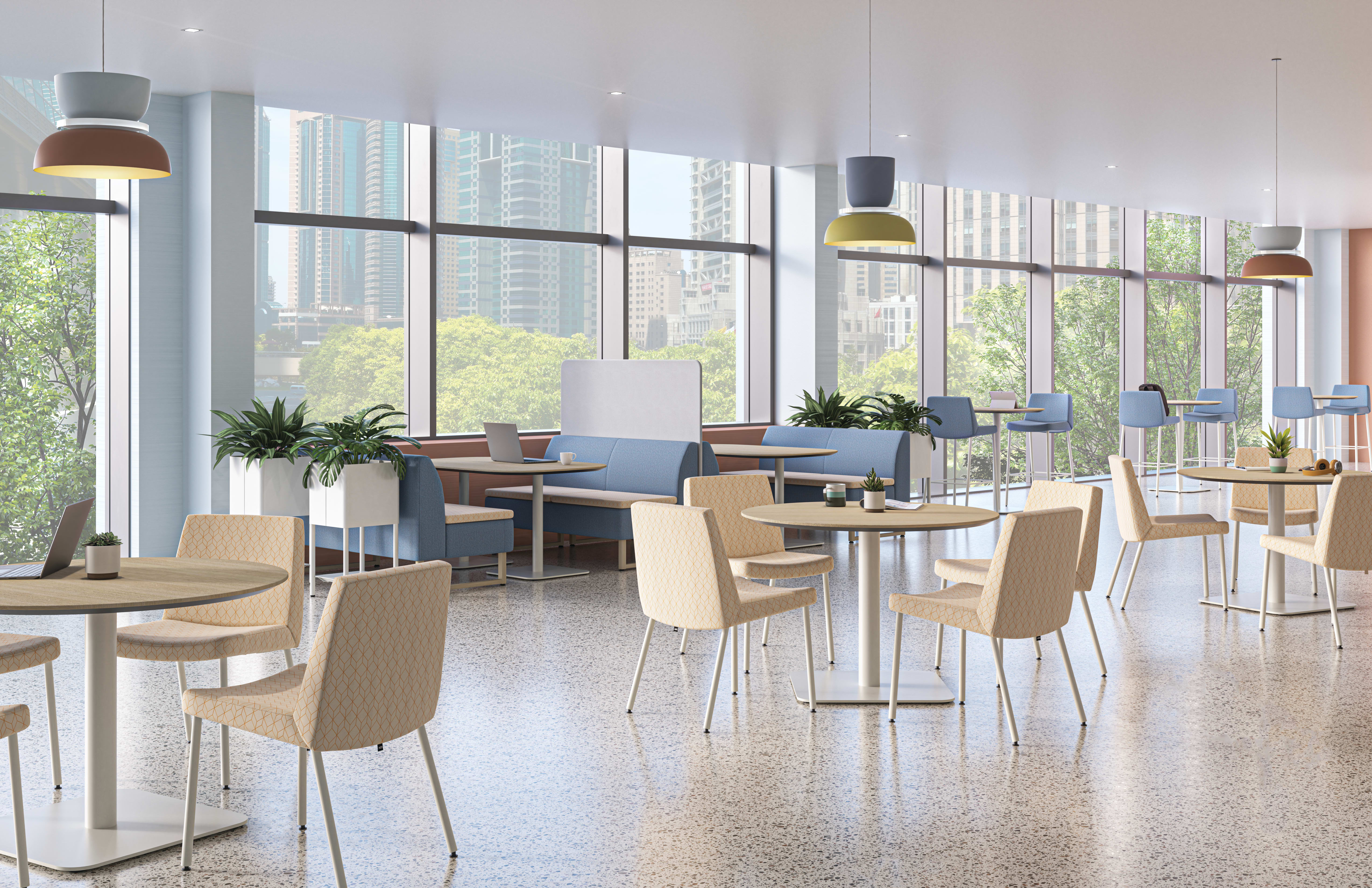 A bright, modern workplace cafeteria with floor-to-ceiling windows, round wooden tables, upholstered chairs, blue booth seating, and colorful pendant lights overlooking a city skyline.