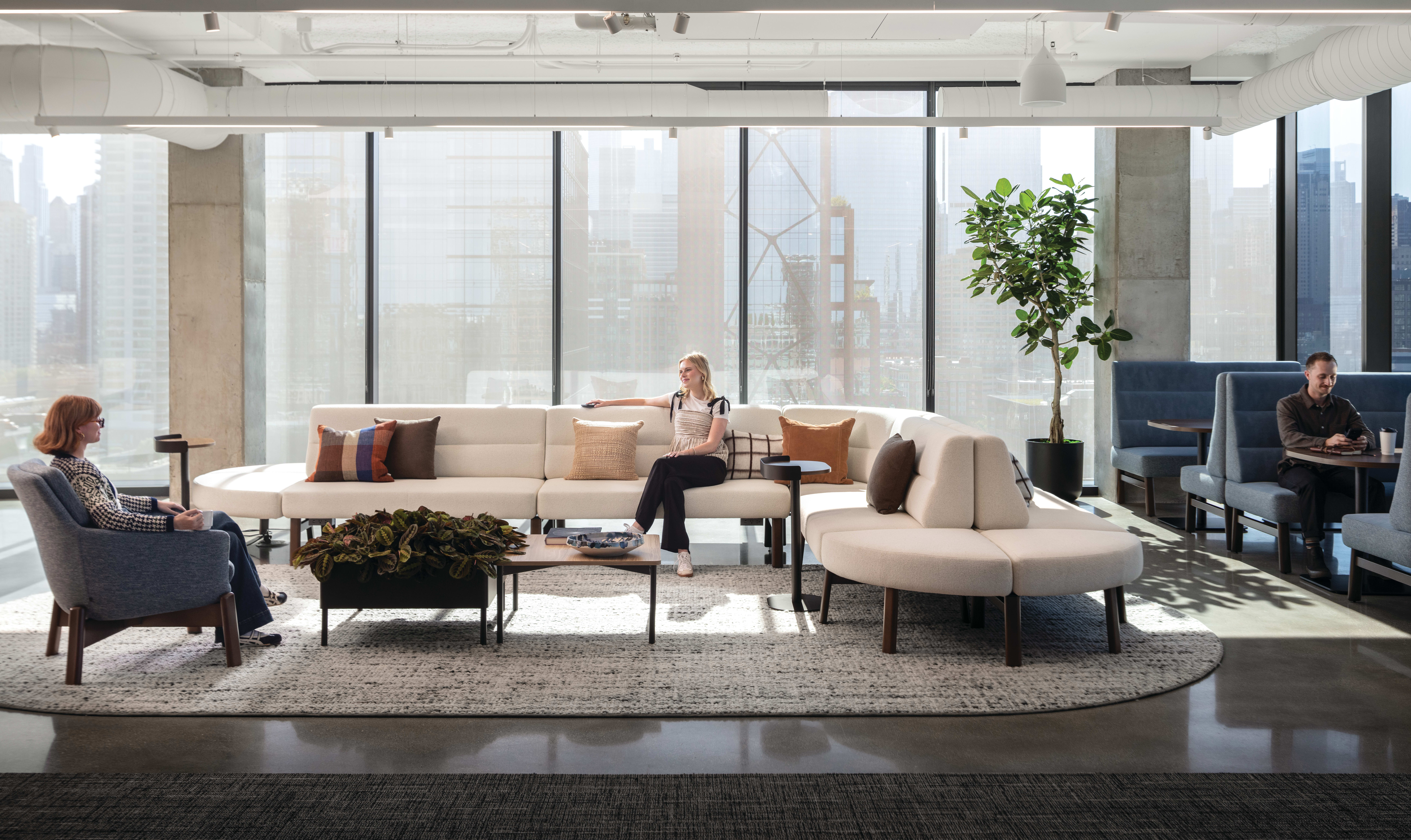 Rectangular coffee table with wood top and slim metal legs, paired with low round side tables for casual lounge use.