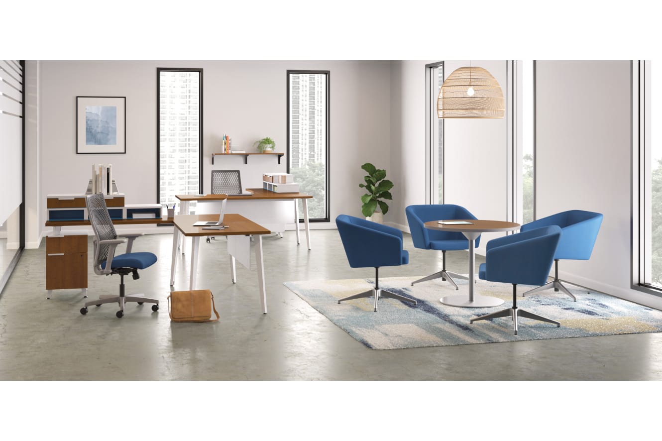 A modern and minimalist office space with a wooden desk, blue chairs, and various decorative elements such as a plant and framed artwork on the walls.
