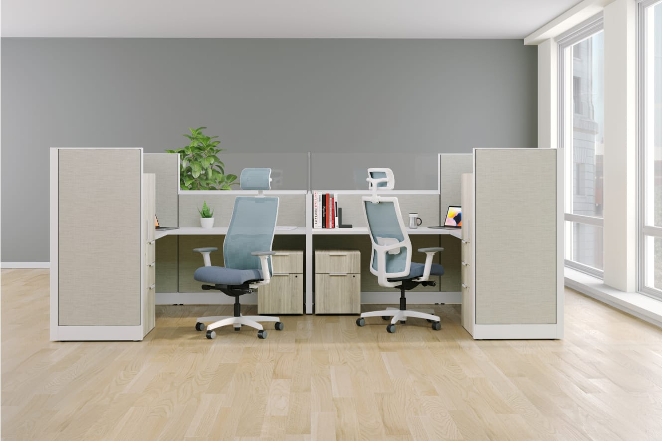 A modern and minimalist office space with white desks, ergonomic chairs, and shelving units, set against a gray wall and hardwood flooring, creating a clean and organized work environment.