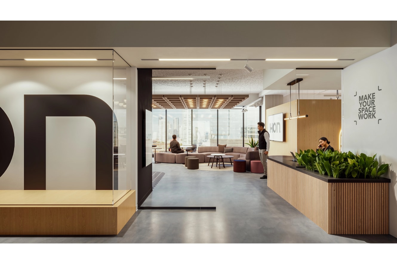 Lounge seating area with upholstered modular sofa, round coffee tables, and soft ottoman seating arranged for casual collaboration.