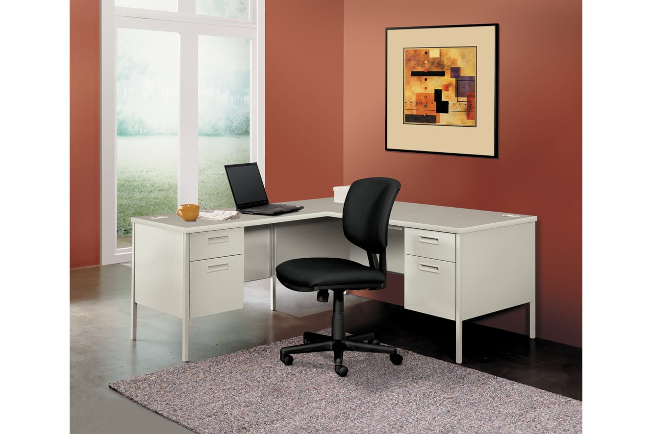 A modern home office setup with a white desk, a black office chair, and a framed abstract artwork on the wall, set against a warm-toned wall color.