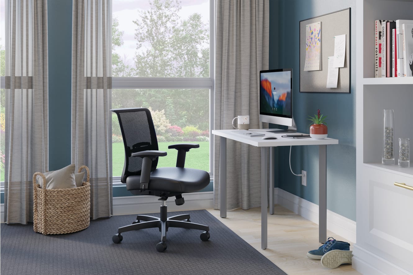 A modern home office with a comfortable office chair, a desk with a computer, and various decorative elements, set against a backdrop of large windows overlooking a natural outdoor scene.