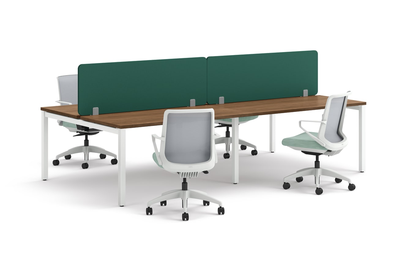 Four ergonomic office chairs positioned around two connected desks with wooden tops, white legs, and green fabric privacy panels.