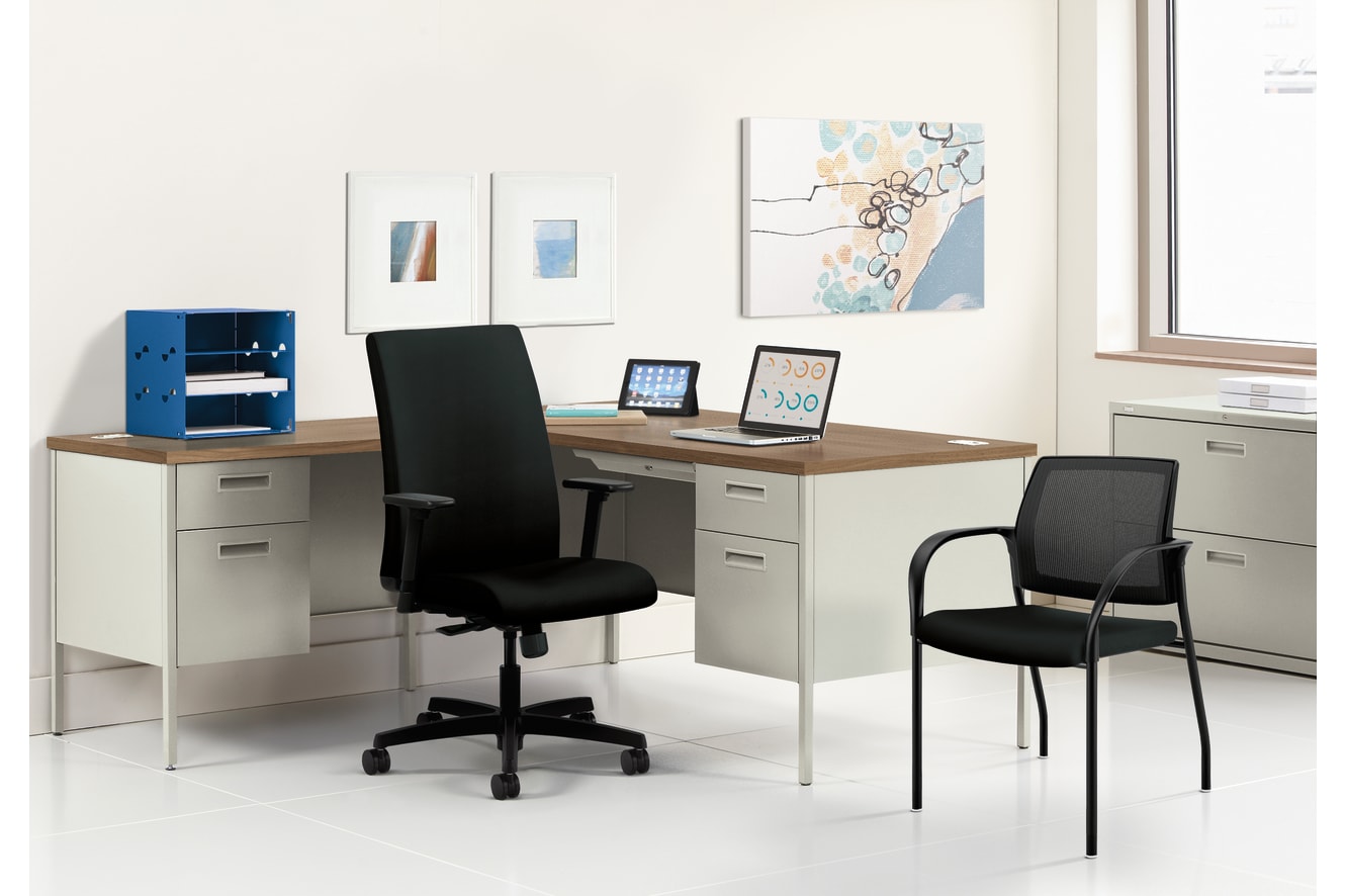 A modern and minimalist home office setup with a wooden desk, black office chairs, and various decorative elements on the walls.