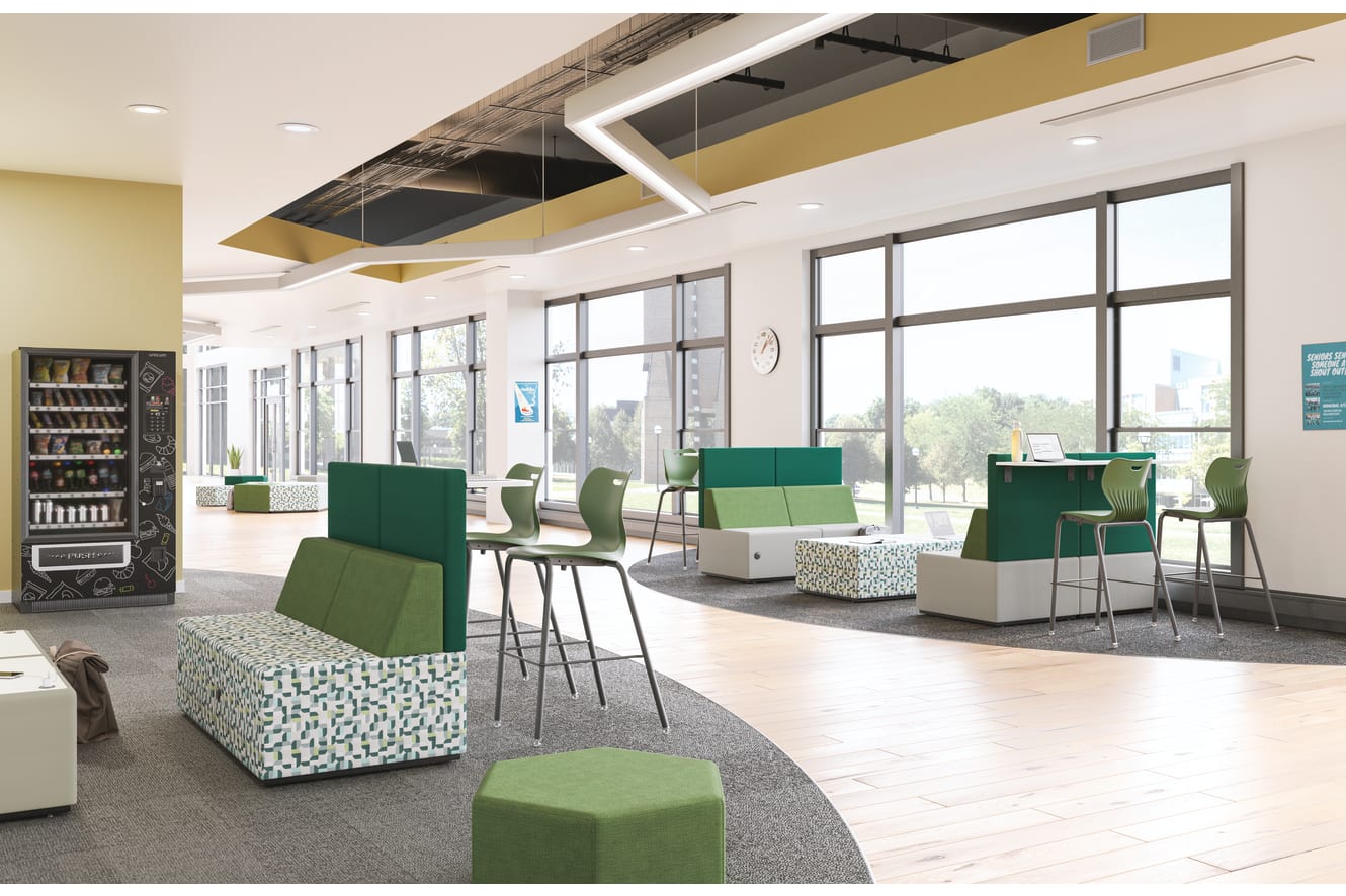 A modern, open-concept office space with green and white furniture, large windows, and a vending machine in the background.