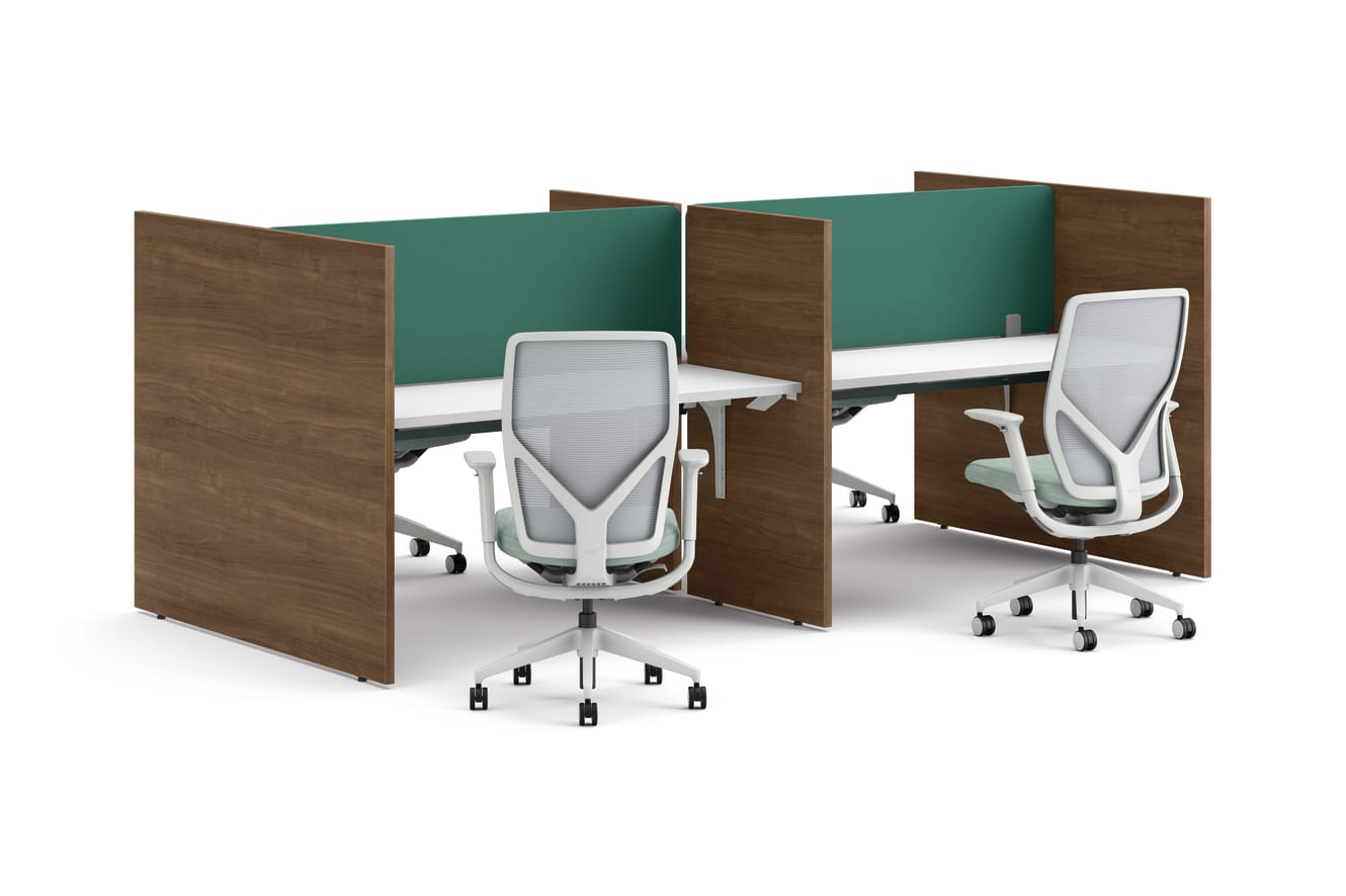 Two workstations with green fabric privacy panels, white desks, and ergonomic office chairs framed by wooden side panels.