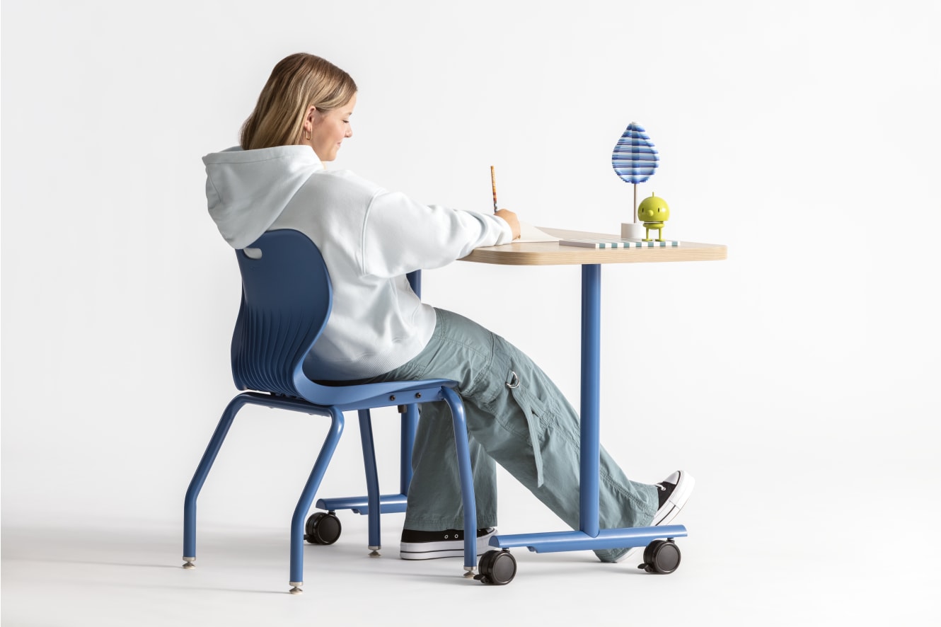 One student seated in a blue monotone Smartlink chair at a Field Trip table with matching blue legs.