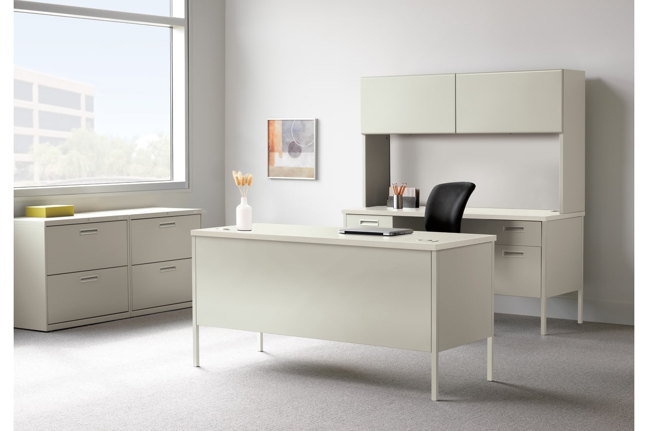 A modern, minimalist office space with a white desk, cabinets, and a framed artwork on the wall, set against a bright, natural light-filled background.