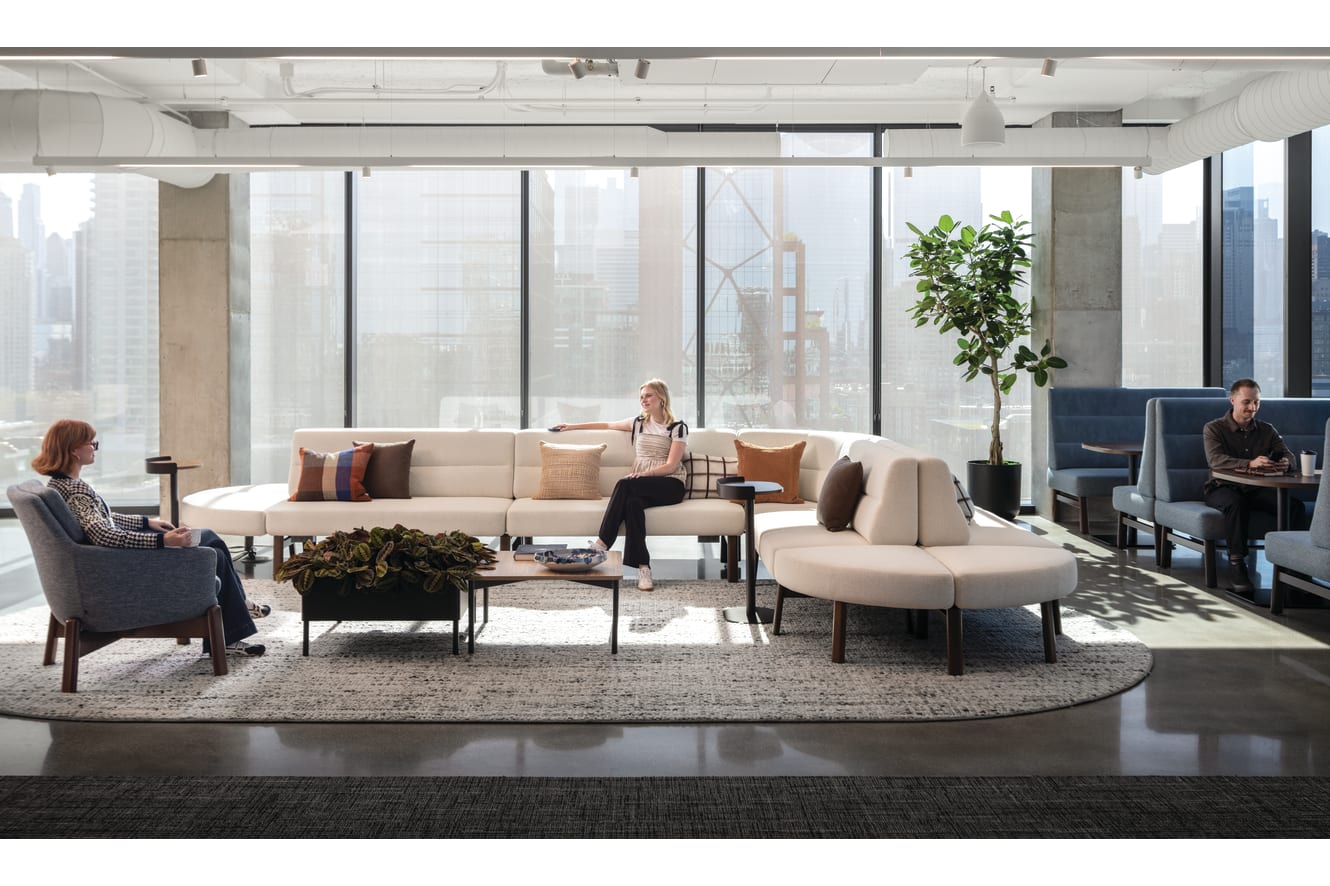 Rectangular coffee table with wood top and slim metal legs, paired with low round side tables for casual lounge use.