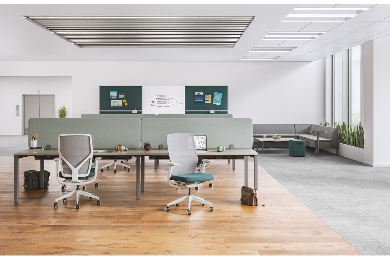 A modern, minimalist office space with a mix of gray and white furniture, including desks, chairs, and storage units, set against a bright, open background.