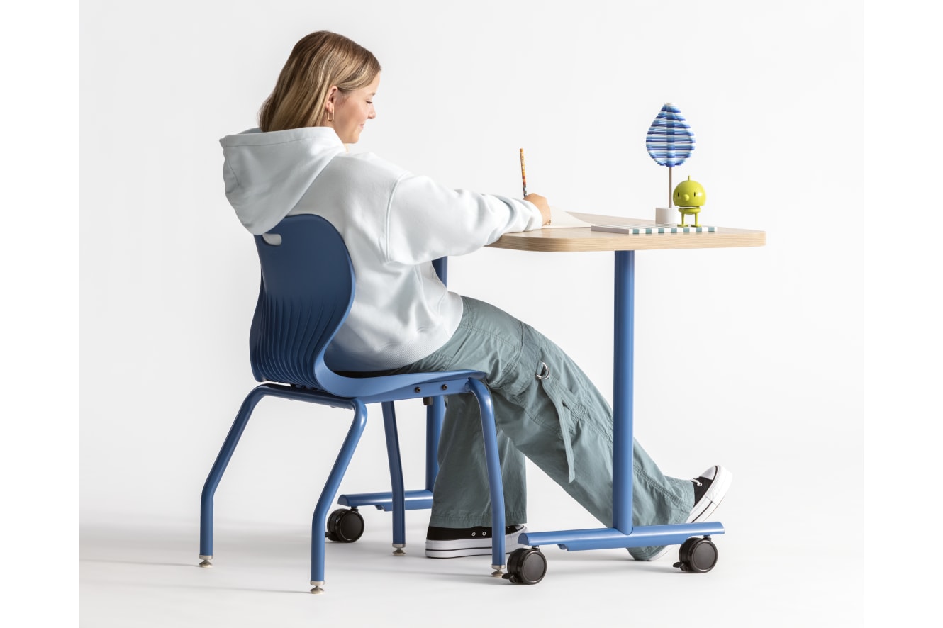 One student seated in a blue monotone Smartlink chair at a Field Trip table with matching blue legs.
