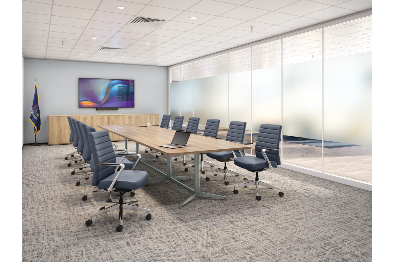 Modern boardroom with long conference table, padded executive chairs, wall-mounted display, glass partition walls, ceiling lighting, and a clean professional setting.