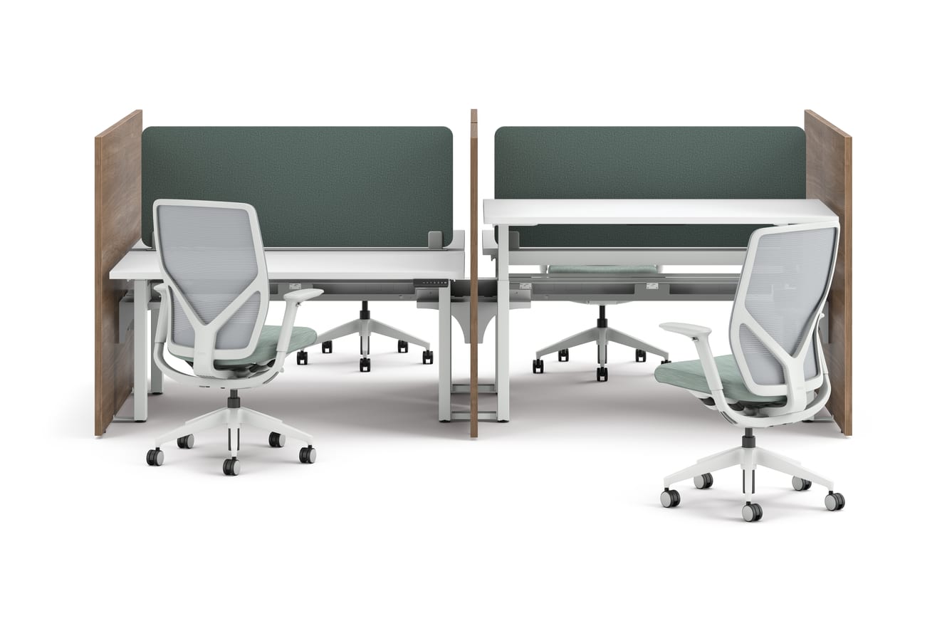 Two workstations with green fabric privacy panels, white desks, and ergonomic office chairs framed by wooden side panels.