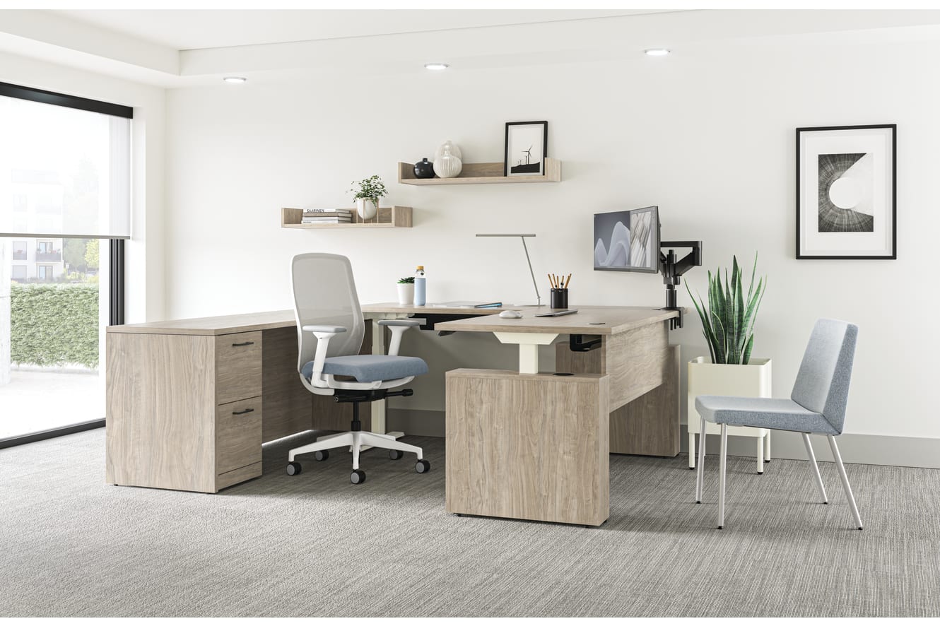 A modern and minimalist home office space with a wooden desk, a gray office chair, and various decorative elements such as shelves, plants, and framed artwork on the walls.