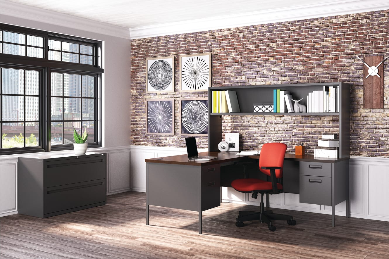 A modern and stylish home office with a brick wall, shelves, a desk, and a red office chair.
