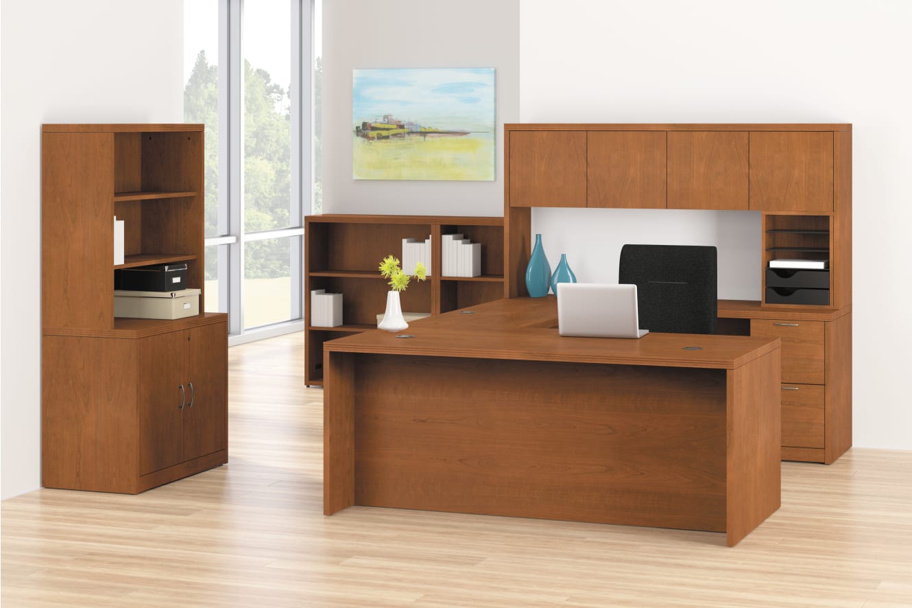 A modern and minimalist home office setup with wooden furniture, including a desk, shelves, and cabinets, against a bright and airy background.