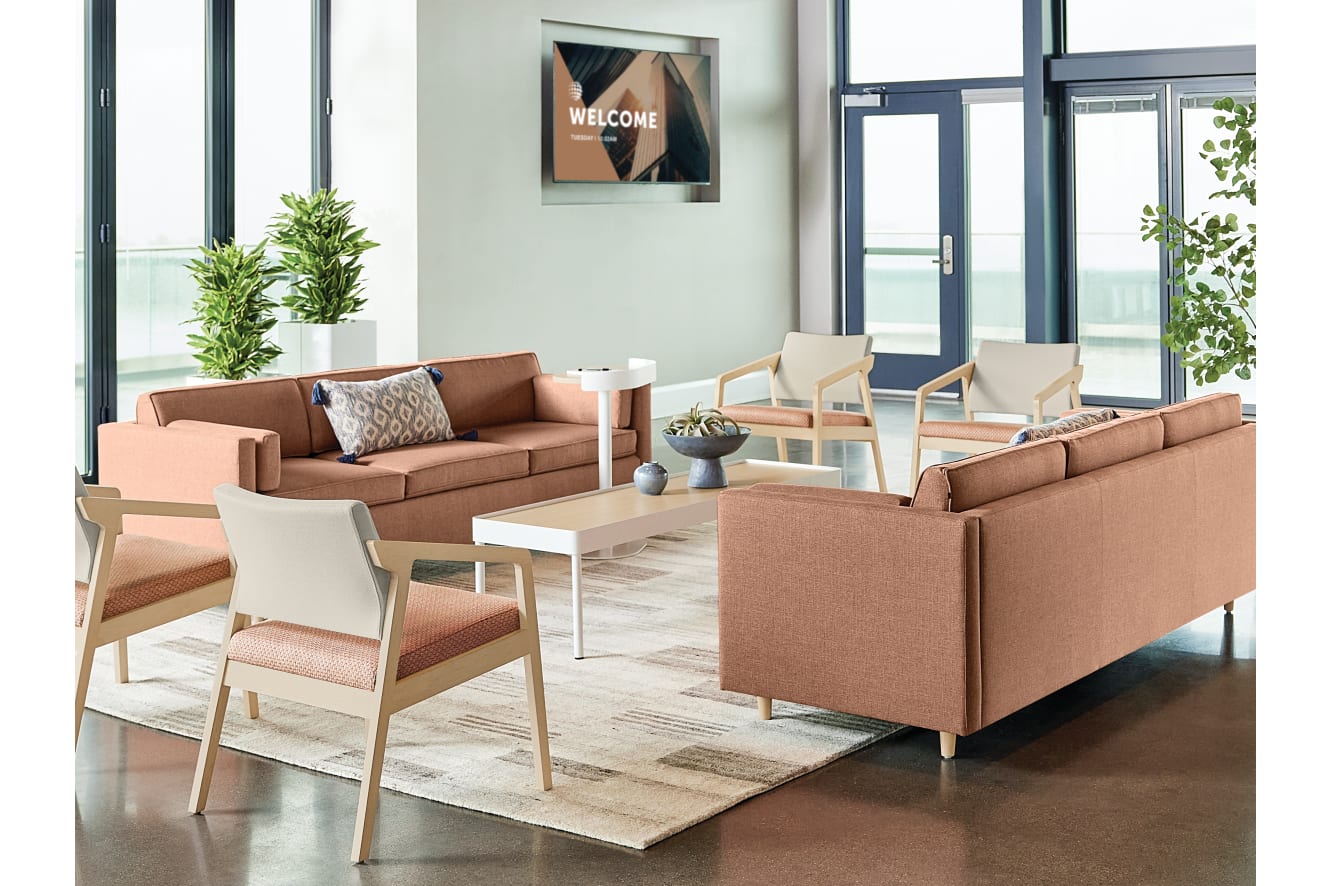 A modern and inviting lobby area with comfortable seating arrangements, potted plants, and a welcoming sign on the wall.
