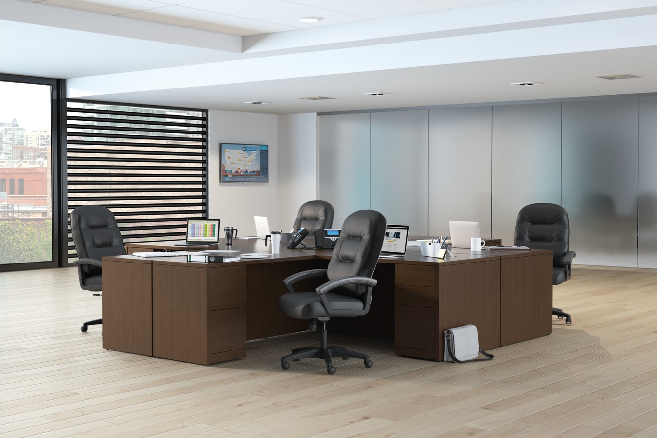 A modern and minimalist office space with wooden desks, black office chairs, and a striped partition wall in the background.
