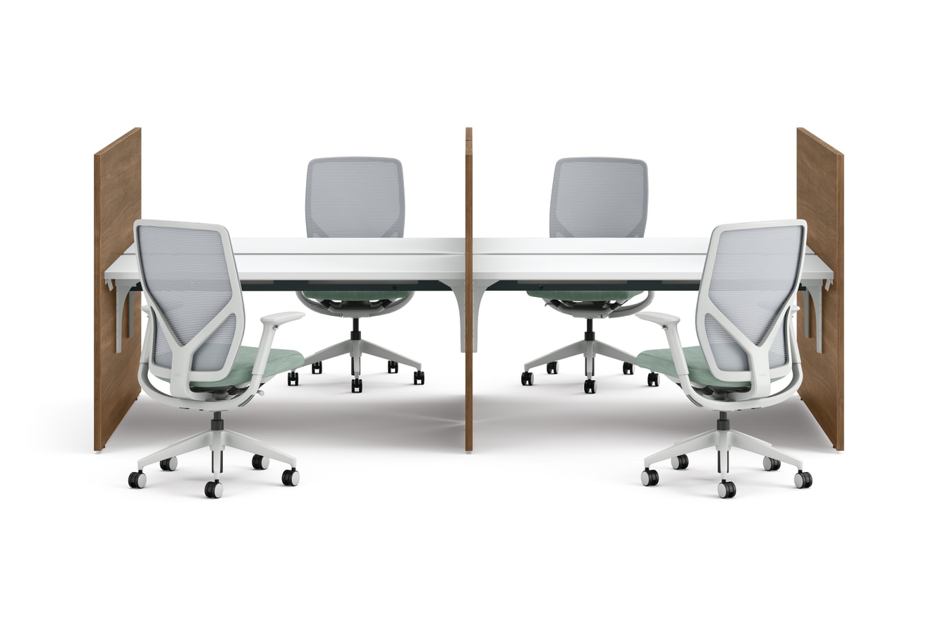 Two workstations with green fabric privacy panels, white desks, and ergonomic office chairs framed by wooden side panels.