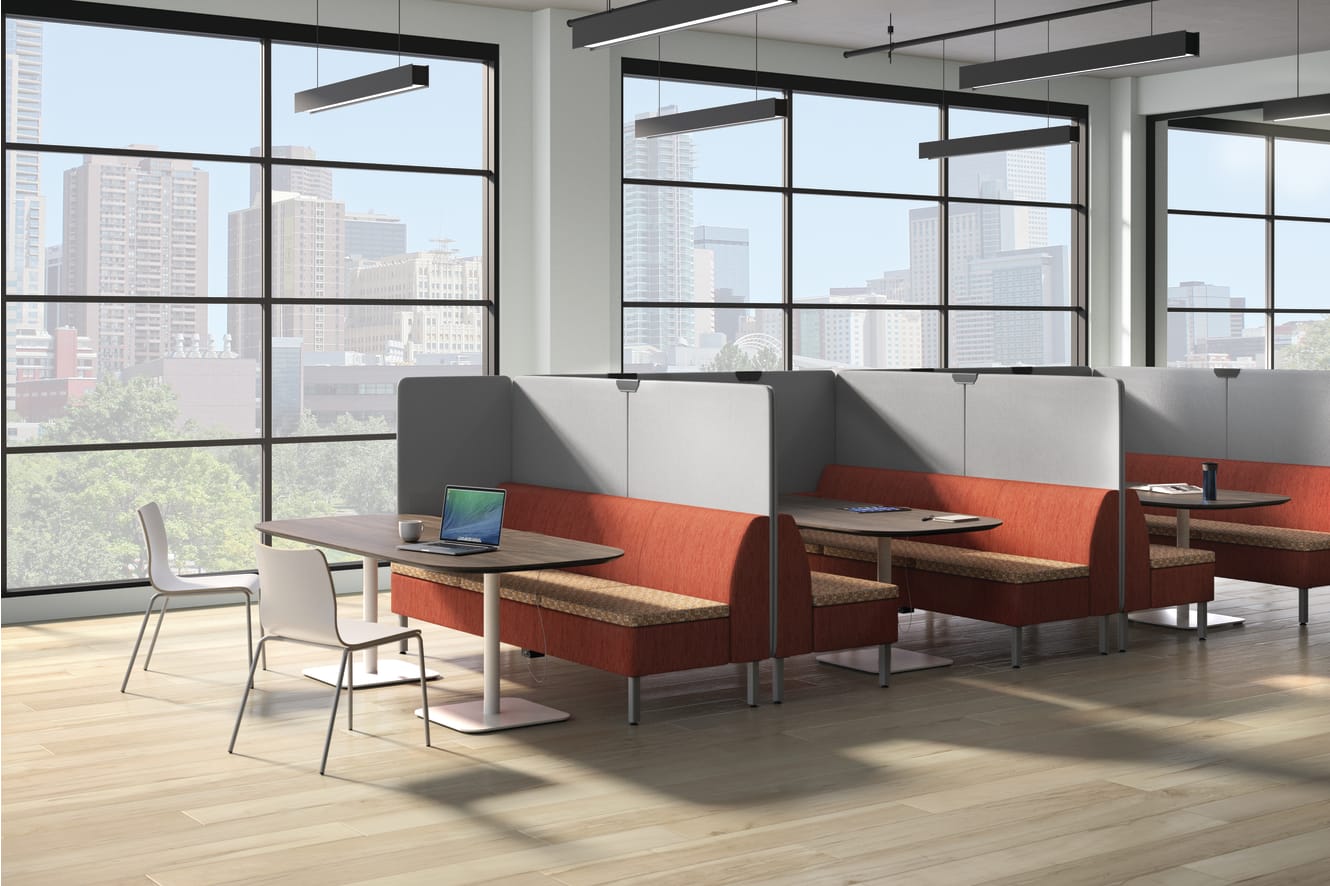 A modern office space with large windows overlooking a cityscape, featuring comfortable seating arrangements and a minimalist design aesthetic.