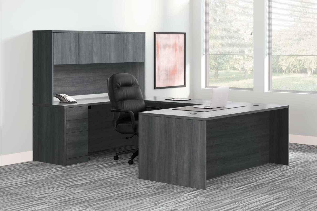 A modern and minimalist office workspace with a dark-colored desk, shelving unit, and a comfortable office chair situated in a bright, airy room with large windows.