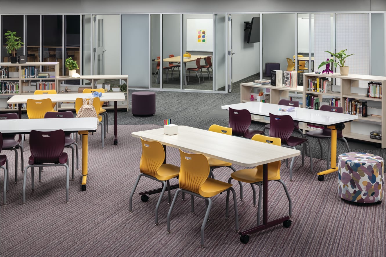 Field Trip tables with purple and yellow Smartlink chairs in a Multi-media Center with Storyline bookcases.