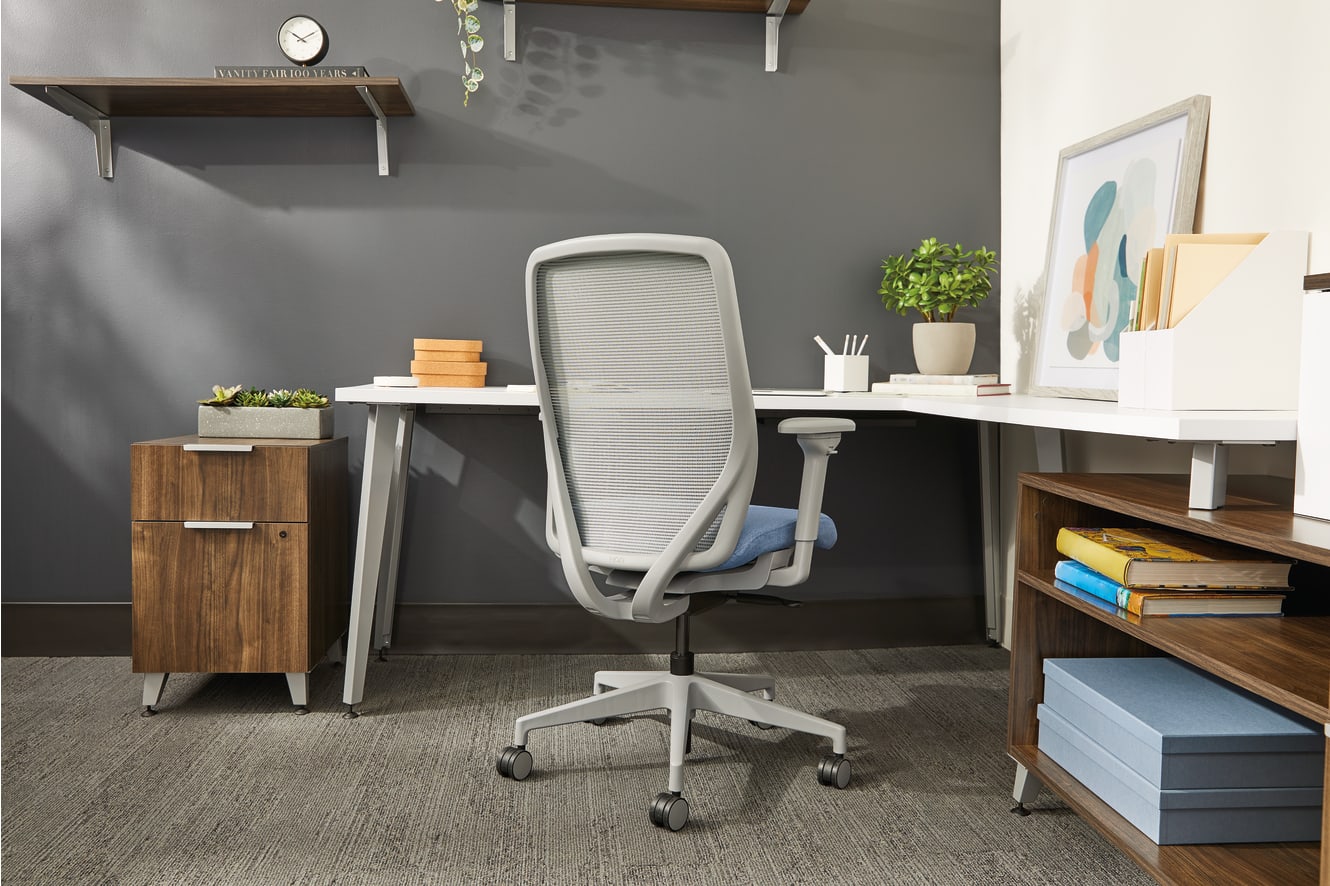 A modern and organized home office space with a comfortable-looking office chair, shelves, and various decorative elements.