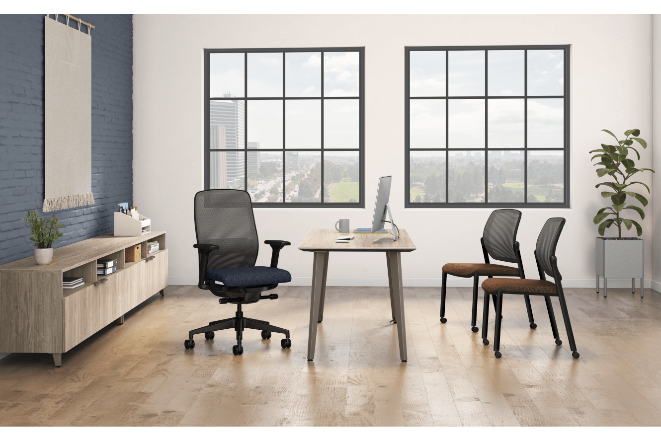 A modern and minimalist office space with large windows, a wooden desk, office chairs, and a storage unit against the wall.