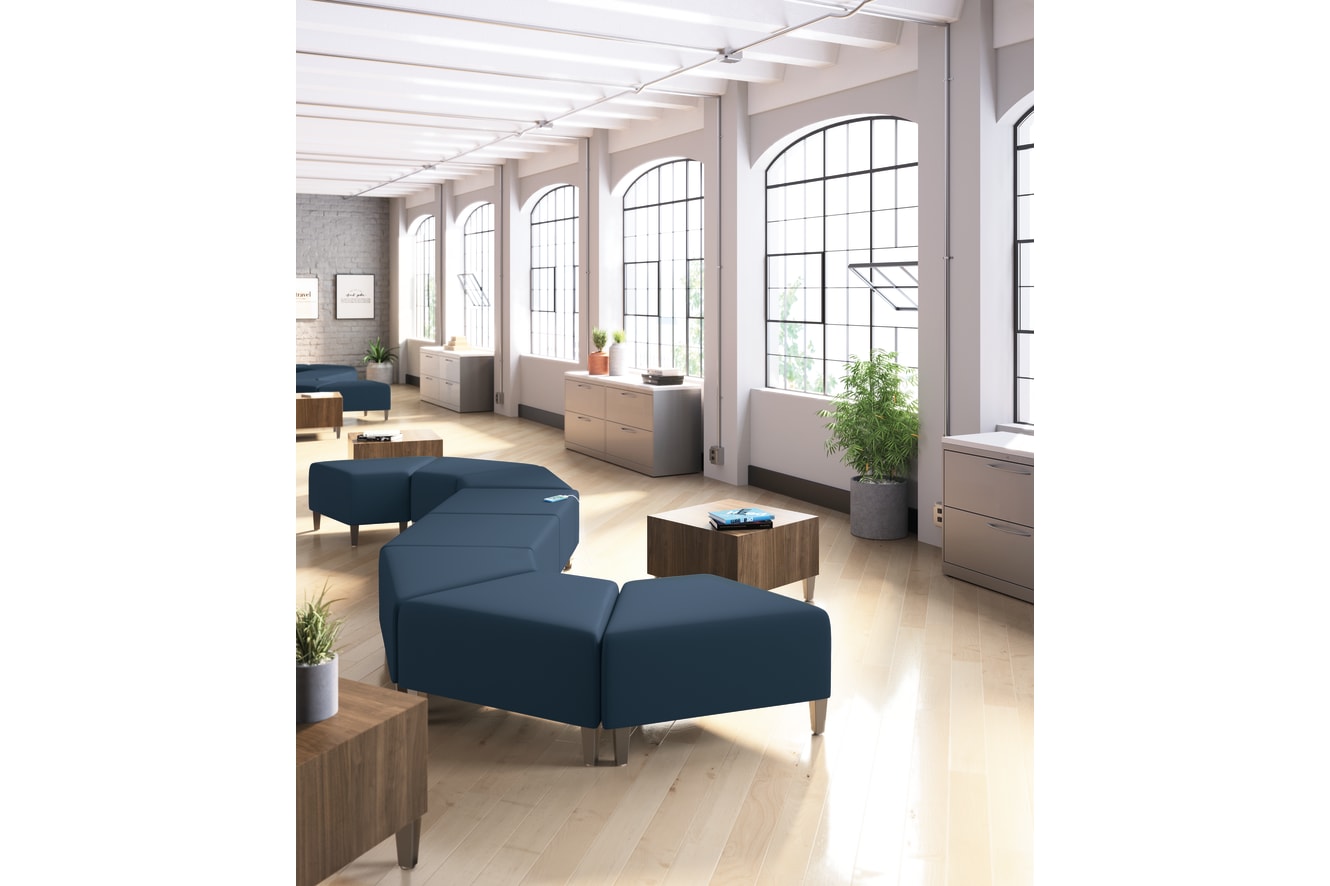 A modern and spacious office space with large windows, wooden furniture, and comfortable seating arrangements.