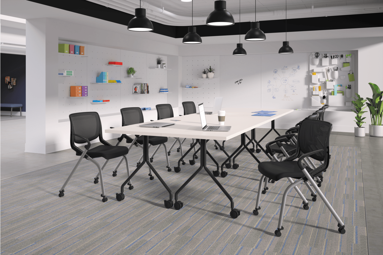 A modern and minimalist office space with a long table, black chairs, and various shelves and decor elements on the walls.