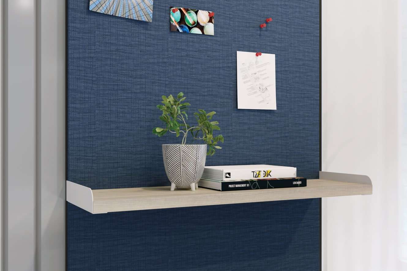 Workwall floating shelf holding small plant and stack of books.