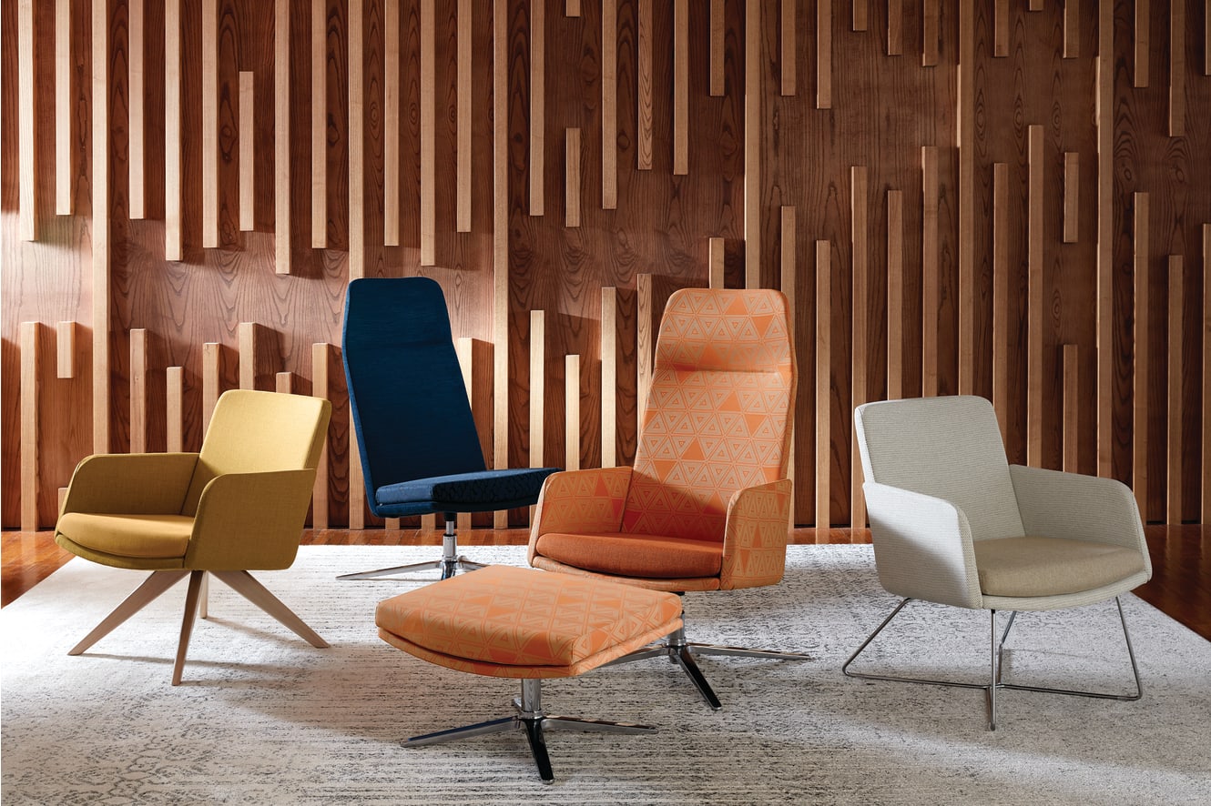 A collection of modern, colorful chairs and ottomans arranged in a room with a striking wooden wall feature.