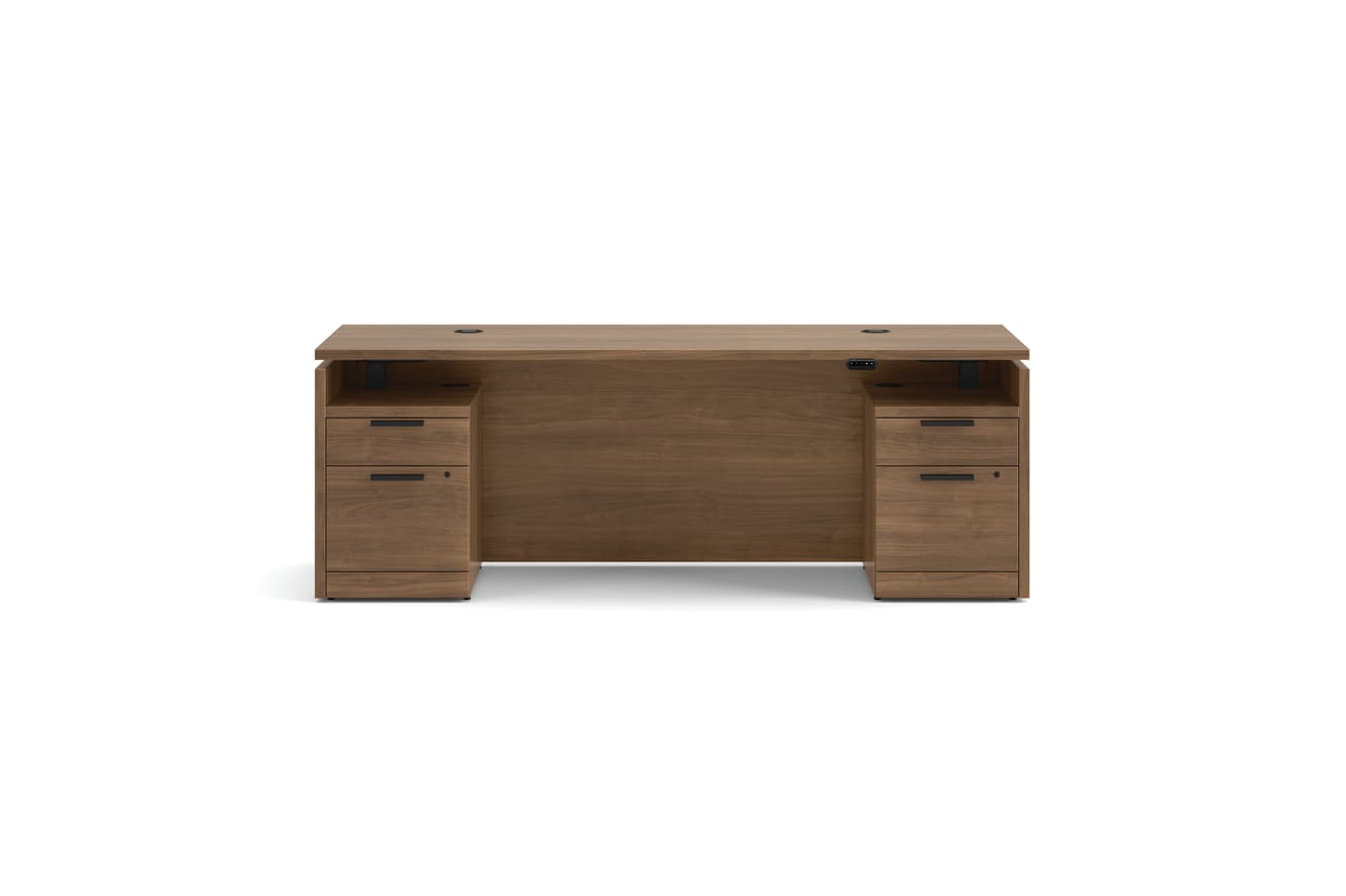 Double pedestal executive desk with woodgrain finish, integrated power access, and built-in file storage.