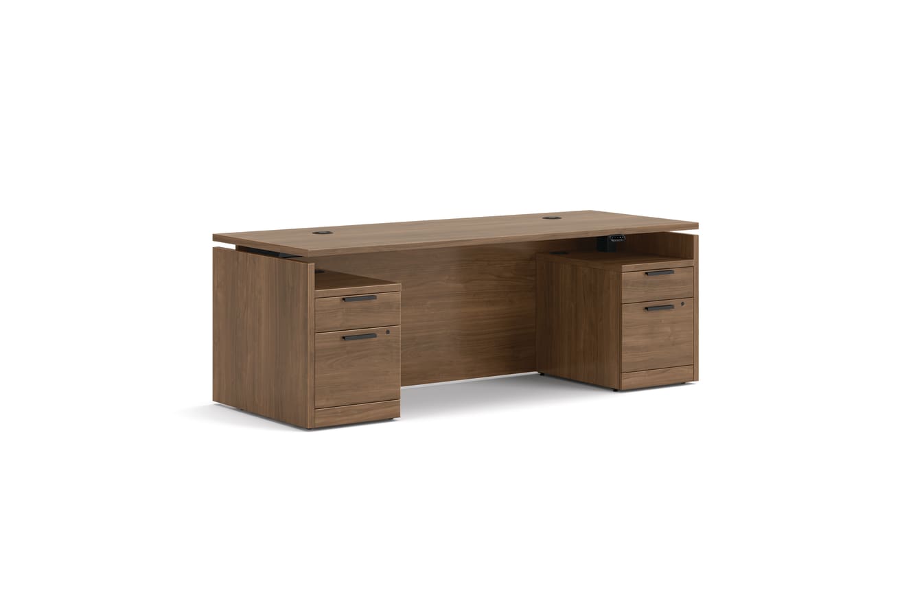 Double pedestal executive desk with woodgrain finish, integrated power access, and built-in file storage.
