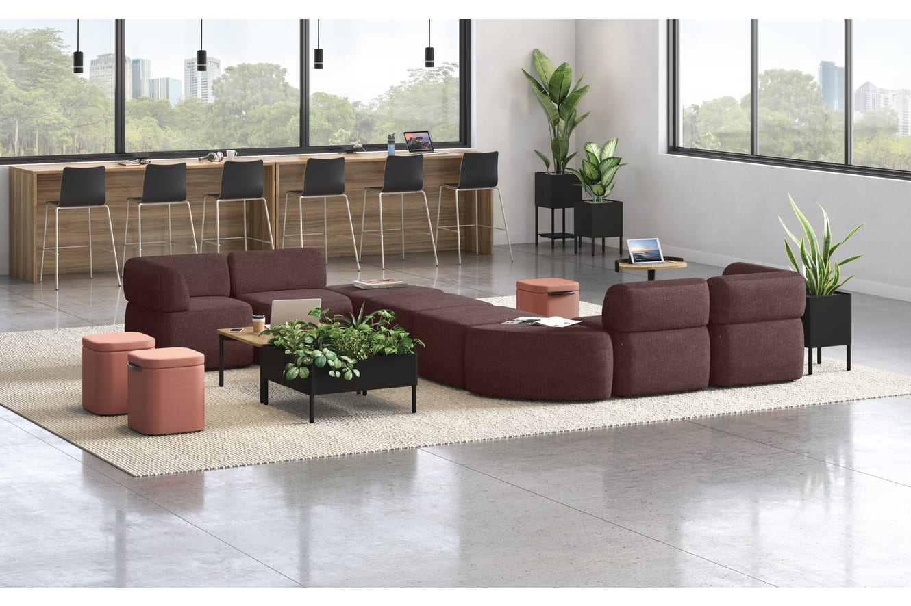 A modern and minimalist lobby or waiting area with comfortable burgundy sofas, potted plants, and a wooden reception desk against a backdrop of large windows overlooking a lush outdoor environment.