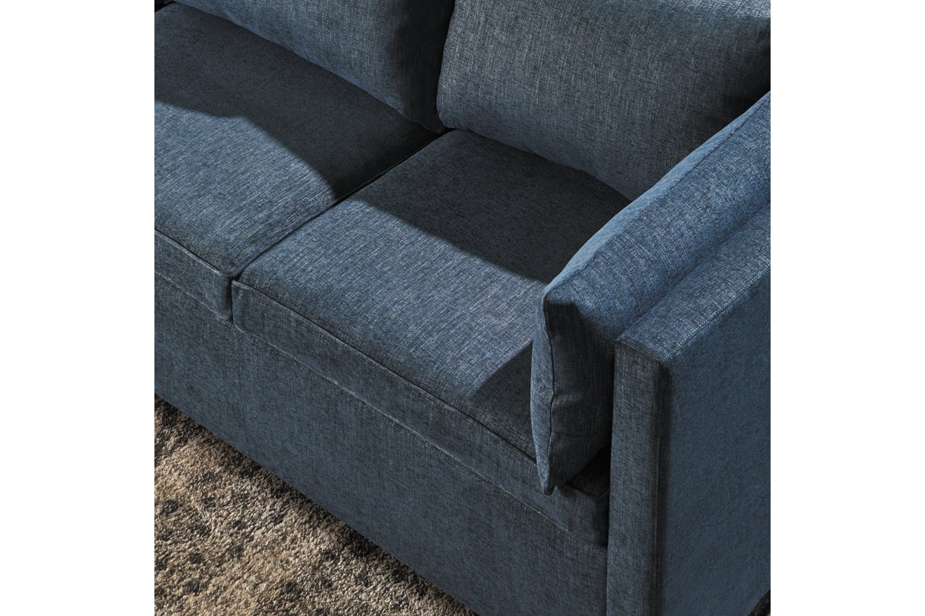 A dark gray upholstered sofa with distinct cushions and armrests sits on a carpeted floor.