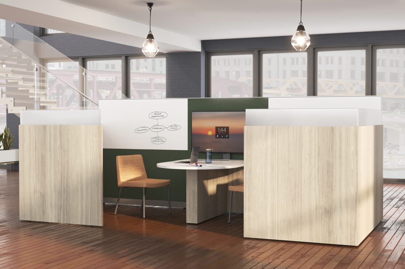 A modern and minimalist office space with wooden floors, white walls, and pendant lighting fixtures, featuring a green and white reception desk and a comfortable-looking chair.